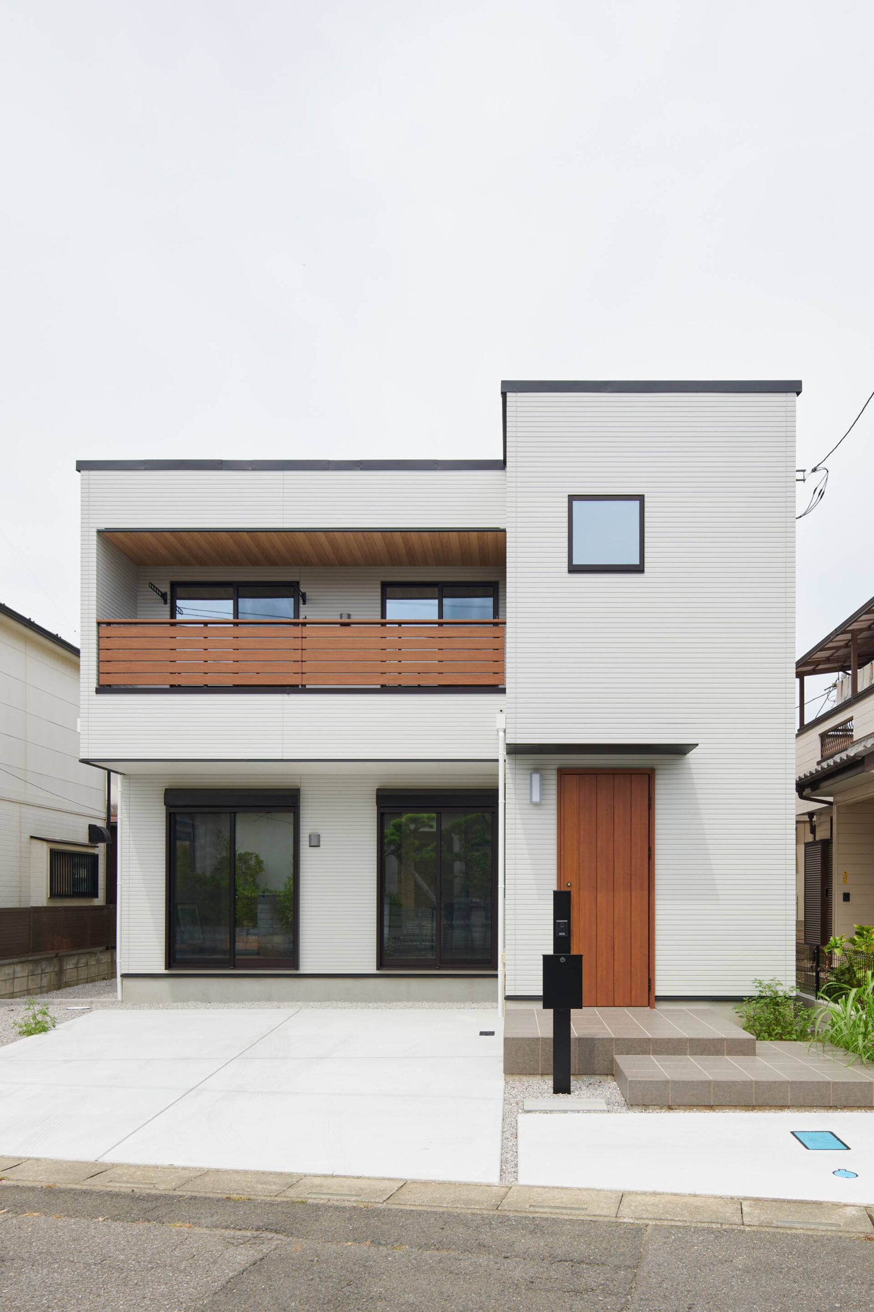 ファサード正面、白と木のシンプルモダンな2階建て住宅