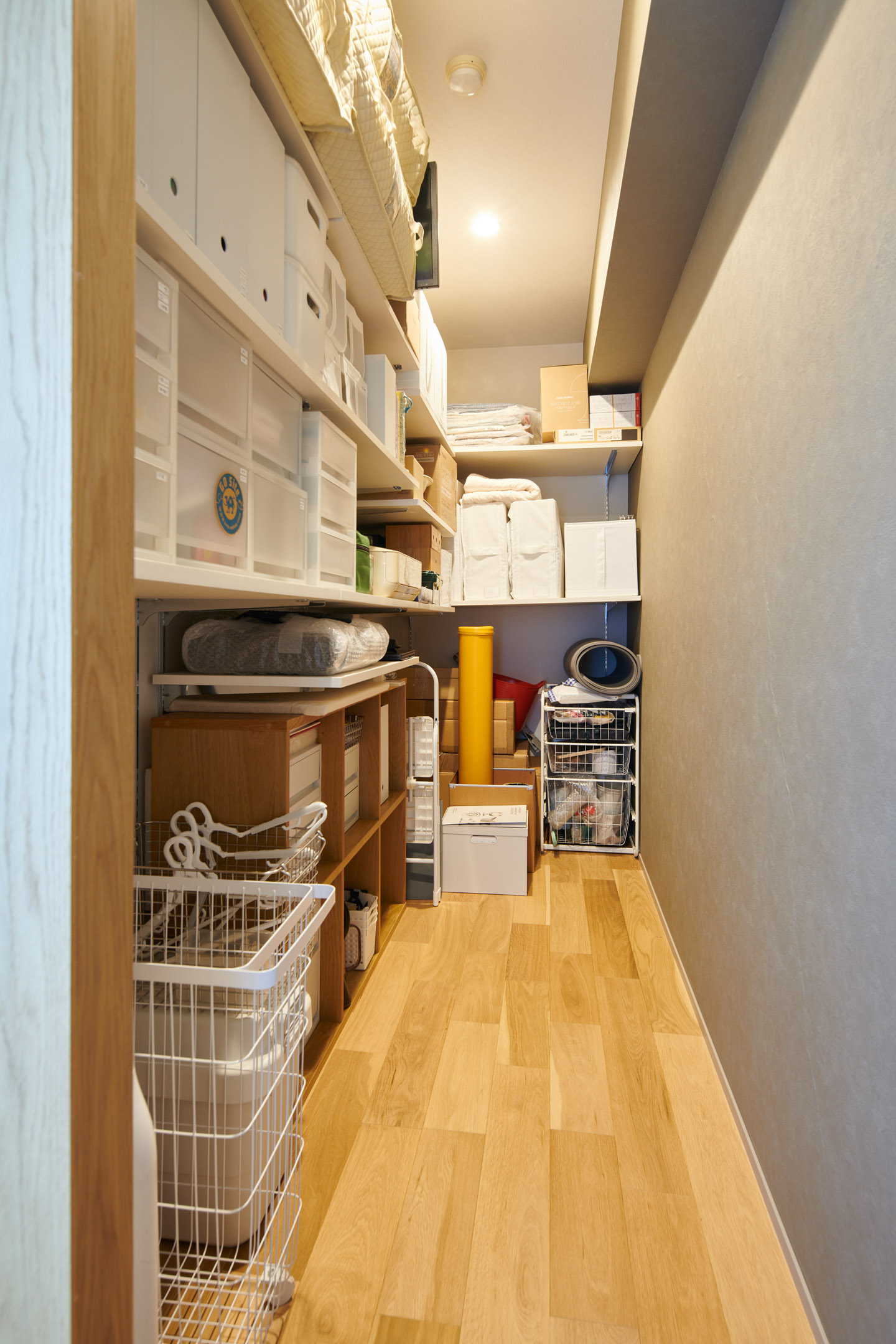 リビング・ダイニングのスペースを圧迫しないようにしつつ使い勝手を考え、歩ける幅を確保。アイロンや掃除機などの日常使いのものから、布団や季節のものなど大きな荷物がメインで収納されている。